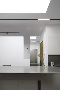 A minimalist kitchen featuring steel countertops and glass cabinets.