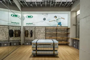 A retail store with a concrete floor and clothing racks.