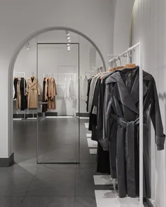 A minimalist clothing retail space featuring metallic and glass materials.