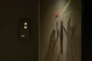 極簡室內設計，擺放黑色花瓶與花卉，並融入金屬元素。