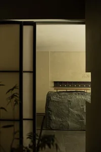 Minimalist living room featuring a large natural stone centerpiece.