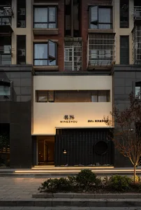 A modern commercial interior features a concrete façade, large windows, and a minimalist design.