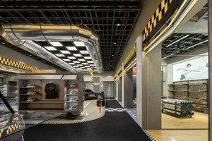 Modern retail interior with metal and concrete elements, showcasing a footwear store with glass display cases and industrial 