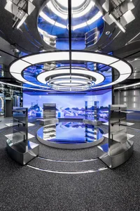 A futuristic, metallic, technology-themed showroom with circular lights and digital displays.