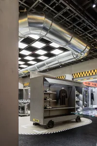 Interior view of a retail store showcasing concrete material and shoe display shelves.