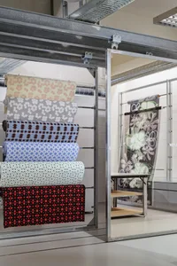 A display of colorful fabric rolls in a showroom setting.