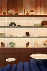 A modern jewelry store display featuring glass jewelry cases and sculptures.