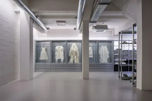 現代零售服裝店內，玻璃展示櫃陳列白色服飾。