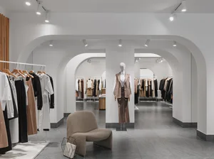 A modern retail interior with neutral-colored apparel displayed on racks and mannequins.