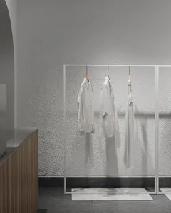 Modern retail store with minimalist white clothing displayed on wooden racks.