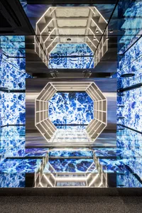 Modern shopping center exhibit featuring metallic frames and a dramatic blue marble backdrop.