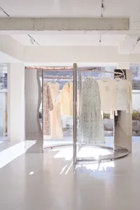 Minimalist retail storefront featuring metal racks with clothing