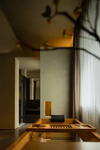 A modern bathroom interior with a wooden table and curtains.