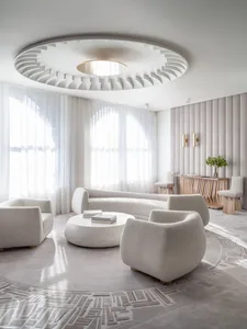 A modern minimalist living room with light-colored fabric furnishings, minimalistic decor, and a geometric carpet pattern.
