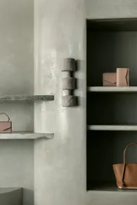 Modern retail space with concrete shelves displaying bags