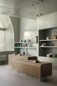 Modern retail space showcasing minimalist design with concrete and porcelain tile finishes.
