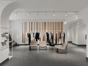 現代精品店採用金屬欄杆、木質元素、混凝土地板與布料服飾設計而成。