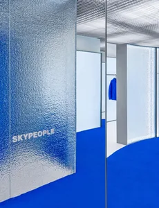 A storefront with frosted glass panels and a blue carpeting, featuring the word Skypepeople.