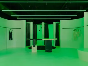 工業風格零售展示間，搭配混凝土飾面與綠色燈光