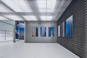 Modern art exhibition space featuring metallic grid walls and panels.