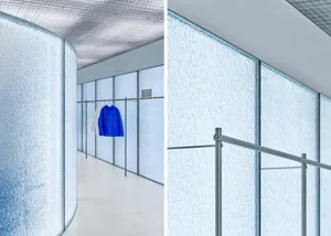 Modern minimalist clothing store interior designed with glass walls, showcasing sleek and contemporary aesthetics.