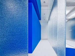 A minimalist interior space featuring metallic surfaces and glass panels.