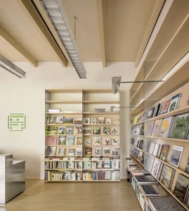 A modern library interior with wooden shelves and glass shelves displaying books.