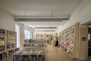 A modern library with wooden shelves filled with books.