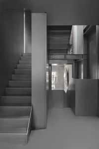 Modern minimalist staircase with metal railing and concrete steps.