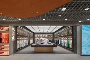 Modern retail space featuring minimalist design with matte black finishes, glass display cases, and exposed brick walls.