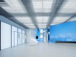 A minimalist retail store interior designed with glass and metal materials.