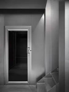 A modern elevator interior with a steel door and minimalist design.