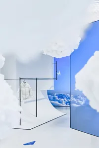 A white jacket hanging on a clothes rack in a shop with cloud-themed decor.