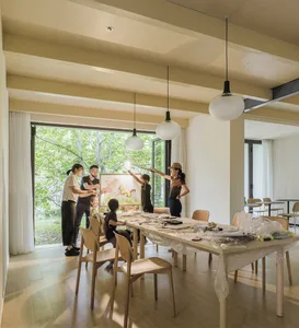 A group of people gathered around a table with art supplies, engaged in an artistic activity.