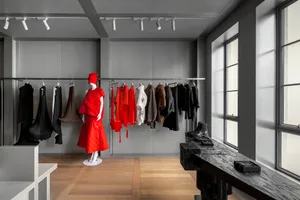 A minimalist clothing shop featuring concrete walls and glass elements.