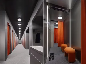Modern clothing store interior with metallic texture curtains, minimalist design, and orange accents.