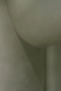 A close-up image of a curved concrete surface with a smooth texture, highlighting architectural details.