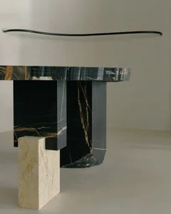 A sleek, modern console table with a curved top made of black marble.