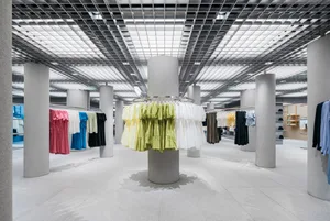 現代服裝零售店室內，搭配混凝土柱與玻璃燈具。