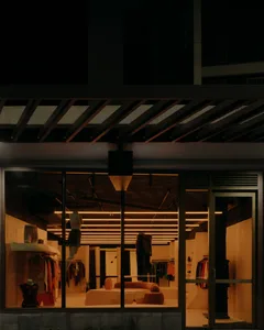 Modern retail shop with glass windows and a concrete ceiling, showcasing a lighting design.