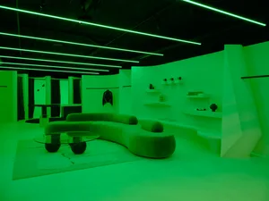 A modern retail store illuminated by green lighting.