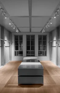 Contemporary showroom featuring white glass furniture on wooden floor.