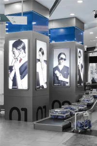 A retail advertisement featuring images of people holding phones, displayed on a modern stand.