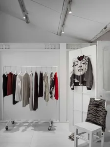 White-walled clothing shop with minimalist fashion display.