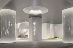 Modern retail storefront with glass façade, concrete pillars, and stone accents.