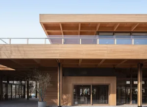 Modern architectural exterior with wooden facade and large glass windows.