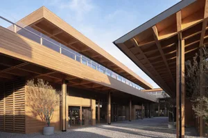 Modern building exterior featuring expansive glass and wooden structural elements.