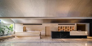 A modern hotel reception desk featuring marble and wood materials.