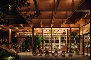 An industrial-style coffee shop interior with wooden elements and potted plants.