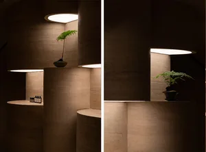 Modern interior design featuring a concrete structure with illuminated lighting and a plant display.